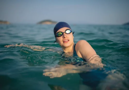 Determined woman swimming in sea.Foung female is enjoying water sport during sunset.